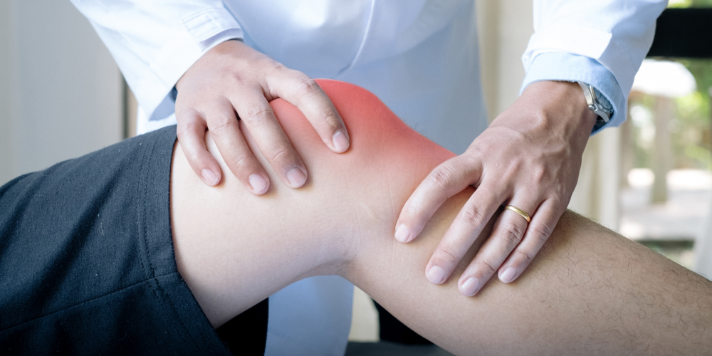 A doctor holds the patient's knees to check for bone injuries one of the common orthopedic injury.